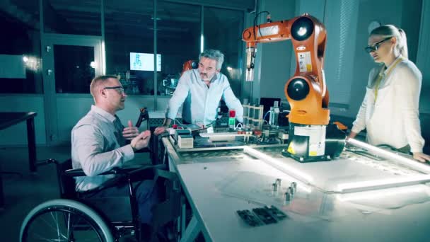 Vammaiset Teknikot Työtoverit Tarkkailevat Robotteja — kuvapankkivideo