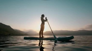 Sakin bir gün batımı. Kadın su birikintisi, denizde su aktiviteleri. 4K