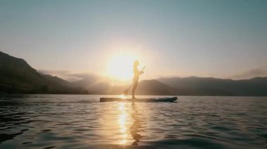 Sakin bir gün batımı. Kadın su birikintisi, denizde su aktiviteleri. 4K