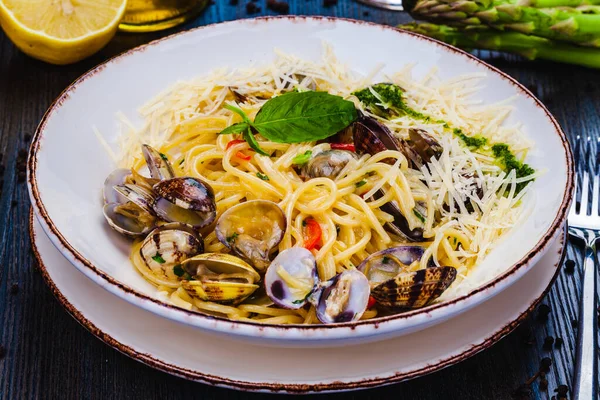 意大利菜海鲜面食配蛤蟆 白盘上的意大利面金银花 免版税图库图片