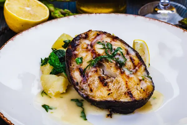 烤鲑鱼牛排 白盘上有土豆和菠菜 图库照片