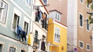 Lizbon 'da dar bir sokak, renkli binalar çerçeveli. Eski binalar arasındaki iplerde çamaşır yıkadım..