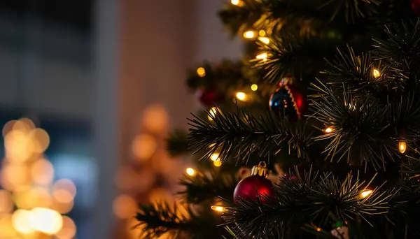 Güzel dekore edilmiş bir Noel ağacına yakın çekim. Işıl ışıl ışık ve süsler ve yemyeşil dallar. Sıcak ve şenlikli bir tatil atmosferi yaratıyor..