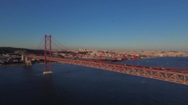 25 Nisan 'da Lizbon, Portekiz' de güneş batarken insansız hava aracı görüntüsü. Ponte 25 de Abril. Tejo Nehri üzerindeki asma köprü.