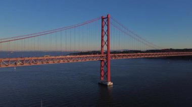 25 Nisan 'da Lizbon, Portekiz' de güneş batarken insansız hava aracı görüntüsü. Ponte 25 de Abril. Tejo Nehri üzerindeki asma köprü.