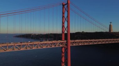 25 Nisan 'da Lizbon, Portekiz' de güneş batarken insansız hava aracı görüntüsü. Ponte 25 de Abril. Tejo Nehri üzerindeki asma köprü.