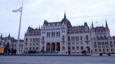 Macaristan 'ın Budapeşte kentindeki Parlamento Binası' nın önünde bir tramvay geçmektedir. Macar bayrağı bayrak direğinde dalgalanır. 24.12.2024