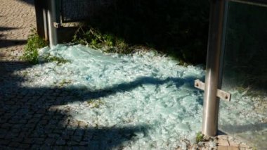 Kırık cam panel parçaları, kaldırım taşlarına saçılmış cam kırıkları. Kırıklar güneşte parlıyor. Yapının yakın zamanda çökmesi. Vandalizm. 