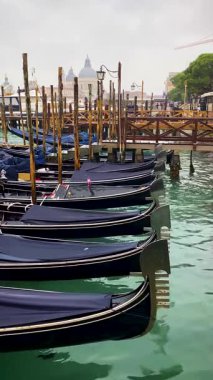 Gondol tekneleri San Marco 'daki Büyük Kanal' da demirlemiş, San Giorgio di Maggiore kilisesinde arka planda. Venedik, İtalya.