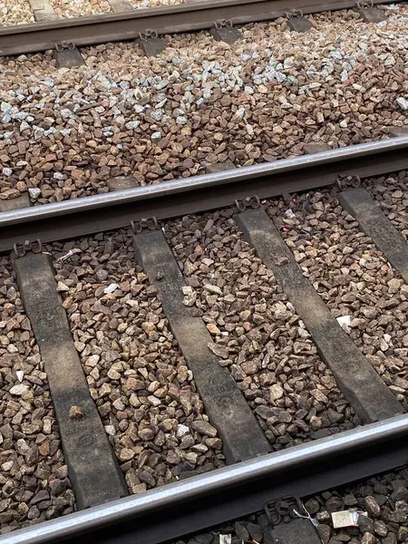 Demiryolu raylarına yakın çekimler çelik raylar, çakıl ağırlığı ve yataklı vagonlar. Parçalanmış taşlar ve rayların yapısal unsurları ulaşım altyapısını, demiryolu mühendisliğini vurguluyor.