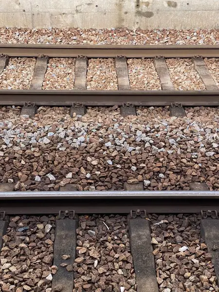 Demiryolu raylarına yakın çekimler çelik raylar, çakıl ağırlığı ve yataklı vagonlar. Parçalanmış taşlar ve rayların yapısal unsurları ulaşım altyapısını, demiryolu mühendisliğini vurguluyor.