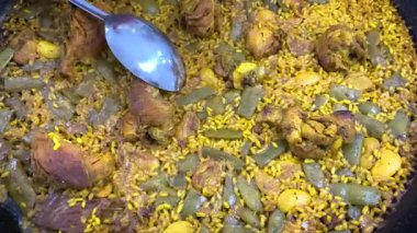 Geleneksel Valensiyalı paella tavada pilav, tavuk, yeşil fasulye ve garrof (lima fasulyesi) servis edilir. Otantik İspanyol mutfağından, ev yapımı ve yemeye hazır..