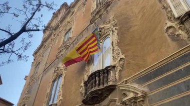 Valencia, İspanya 'da bir binanın cephesinde rüzgarda sallanan İspanyol bayrakları.