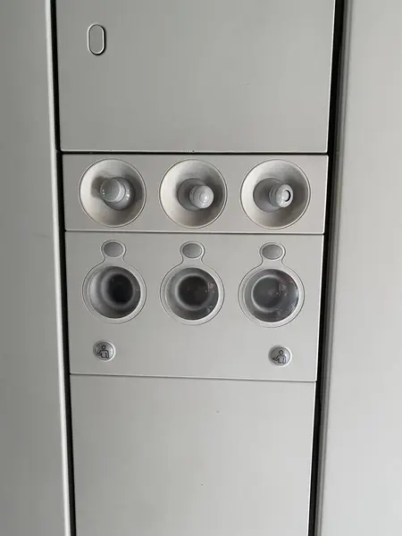 Hava delikleri ve yolcu koltuklarının üstündeki ışıkları gösteren uçak kontrol panelini kapatın. Modern uçak kabini iç mimarisi.