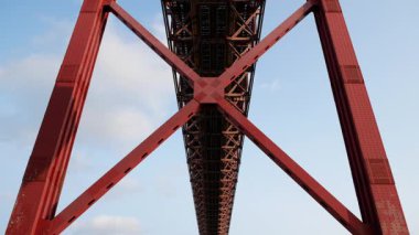 Portekiz, Lizbon 'daki 25 de Abril Köprüsü' nün düşük açılı yakın plan görüntüleri, kırmızı çelik yapının endüstriyel kentsel ruh halini, estetiğini ve kalın geometrik yapısını vurguluyor.. 