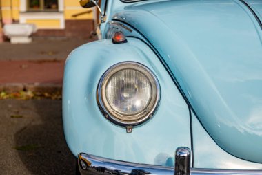 Farları olan klasik arabanın önünde.