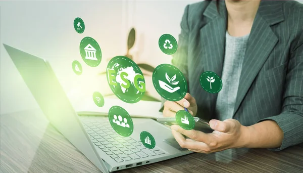 ESG environment social governance investment business concept. Women use a computer to analyze ESG, surrounded by ESG icons .close to the computer screen in business investment strategy concept.