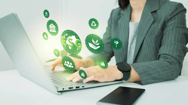 ESG environment social governance investment business concept. Women use a computer to analyze ESG, surrounded by ESG icons .close to the computer screen in business investment strategy concept.