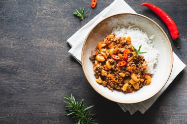 Chili Con Carne kasede, arka planda. Meksika mutfağı. Chili con carne - domates soslu kıyma ve sebze yahnisi. Üst görünüm