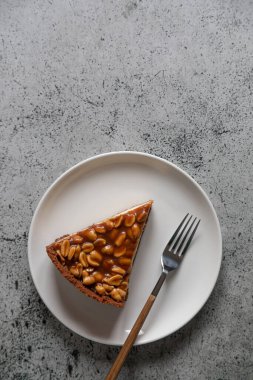 Hafif arka planda ev yapımı karamel fıstıklı cheesecake. Günaydın lezzetli pastane pastası..