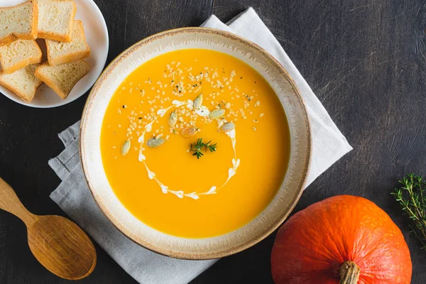 Roasted pumpkin and carrot soup with pumpkin  and hemp seeds. Pumpkin traditional soup with creamy silky texture