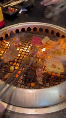 Grilled food. Eating Buffet food in a Japanese restaurant. Meat lover buffet. People grilling meat. vertical video.
