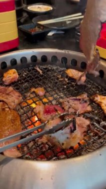 Grilled food. Eating Buffet food in a Japanese restaurant. Meat lover buffet. People grilling meat. vertical video.