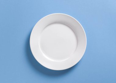 Pastel mavisi üzerinde beyaz yemek tabağı