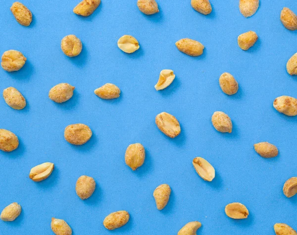 Peanuts on blue flat lay.