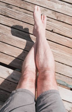 Kırsal ahşap basamaklarda rahatlayan bacaklar ve çıplak ayaklar.