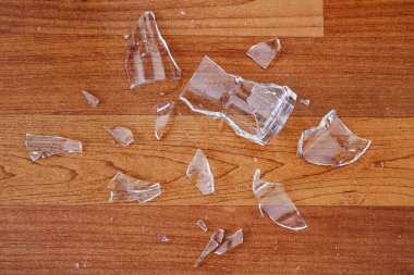 Kırılmış ya da kırılmış. Ahşap zeminde cam kırıkları var.