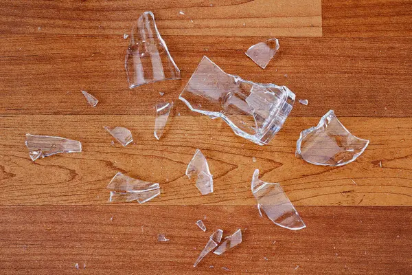 Kırılmış ya da kırılmış. Ahşap zeminde cam kırıkları var.