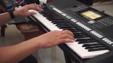 Piyano çalan bir bestecinin elleri, sentezleyici, elektronik piyano klavyesi. Bir etkinlikte görünüm.