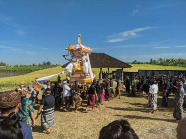 Bali, Endonezya - 19 Mayıs 2023: Tabanan 'da Balili yakma töreni (Ngaben). İnsanlar tahta bir wadah (tapınak benzeri bir yapı, üzerinde tabut) taşırlar mezarlara.