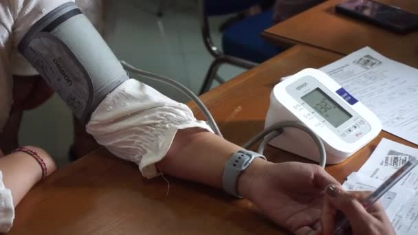 バリ島 インドネシア 2023年5月19日 医師は 病院での予約時の緊張をチェックするために上腕モニターを使用して診療所 セラピストで患者の動脈血圧を測定します — ストック動画