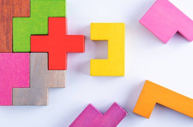 Yaratıcı ve mantıklı düşünme kavramı. Farklı renkli şekiller, beyaz zemin üzerinde tahta bloklar, düz döşeme, kopyalama alanı. Geometrik şekiller, farklı renkler, üst görünüm. Soyut Arkaplan.