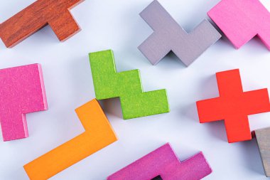 Yaratıcı ve mantıklı düşünme kavramı. Farklı renkli şekiller, beyaz zemin üzerinde tahta bloklar, düz döşeme, kopyalama alanı. Geometrik şekiller, farklı renkler, üst görünüm. Soyut Arkaplan.