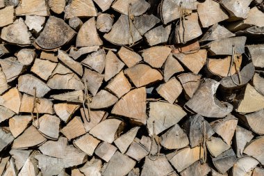 Firewood stacked near the wall close-up. Background made of firewood