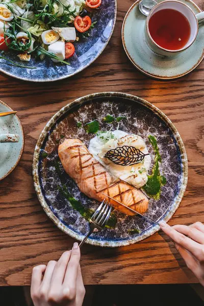 Taze salata ve kremalı patates püresi ile servis edilen lezzetli ızgara somon.