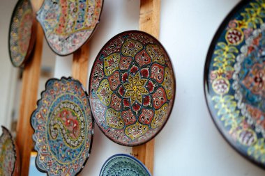 Renkli dekoratif tabaklar. Özbek kültürünün geleneksel el yapımı seramikleri. Elle boyanmış İslami süs yemeği. Orta Asya dekoratif hatıra ve hediyesi. Kültürel miras ve yaratıcılık.