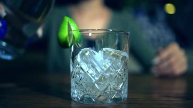 Güzelce kesilmiş kristal bir bardakta servis edilen, içinde buz küpleri ve bir dilim limon bulunan iyi hazırlanmış bir kokteyl. Buzlu bardağa boşaltılmış karbonatsız sıvı..