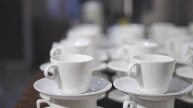 Samimi bir kafe atmosferini ön plana çıkaran beyaz kahve fincanları düzgünce yerleştirildi. Kurulum, içeceklerden keyif almak için rahat ve davetkar bir ortam öneriyor..