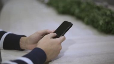 Erkek insan akıllı telefondan özümser, arkadaşlarıyla iletişim kurar ve içeriğe göz atar. Cep telefonuyla mesajlaşan erkek parmaklarını kapat. Sosyal ağ oluşturma kavramı.