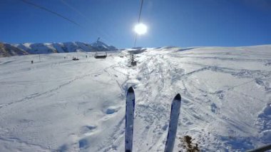 Güneşli kış günlerinde kayak merkezinin tepelerinde teleferiğe binmek. Dağlarda kayak kaldırma.