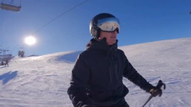 Güneşli kış gününde el değmemiş yamaçlarda kayan tanınmamış kişi. Adam dağ evinde kayak yapmayı seviyor. Kar yamaçlarında süzülen profesyonel bir sporcu..