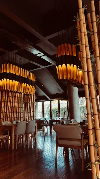 Bishkek, Kırgızistan - 21 Şubat 2025: Çin restoranı içi. Gündüz vakti modern restoranda bambu aksanları ve şık ışıklandırma kullanılıyor..