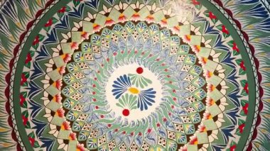 Çarpıcı mandala tasarımı canlı renkler ve detaylı desenler içeriyor ve sanatsal güzelliğiyle izleyicileri cezbediyor. Bu büyüleyici sanat eseri, zanaatkarlığın tefekkürünü ve takdir edilmesini davet ediyor..