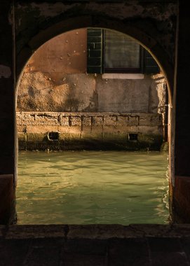 Arch passageway leading to a canal in Venice, Italy.