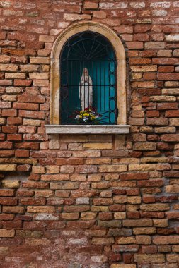 shrine of the Virgin Mary in an old brick wall. 