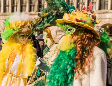 People wearing elaborate and colorful costumes and masks during the Venice 2023 carnival in Venice, Italy